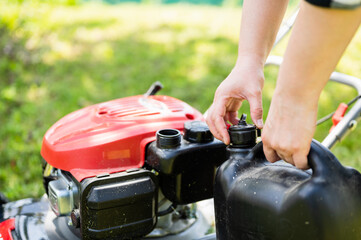 Filling the lawn mower tank with fuel - obrazy, fototapety, plakaty