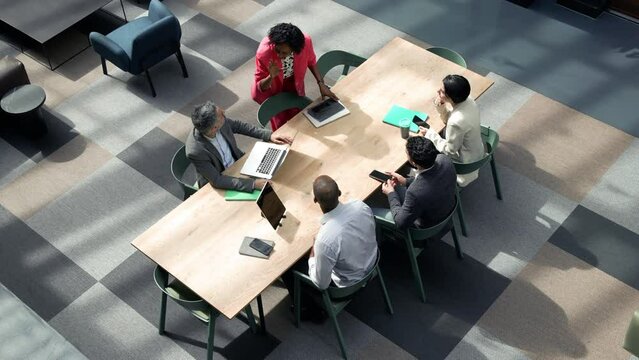 Business people having meeting at table in open space office / London, UK