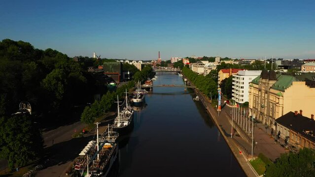 Aerial view over the Aurajoki river, summer sunrise, in Turku, Finland - reverse, drone shot