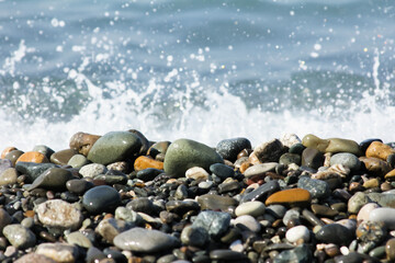 Wet smooth stones with water splashes in the background