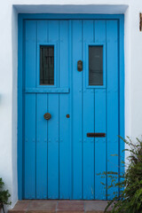 Blue wooden door with windows in Frigiliana, Malaga. Andalusia, Spain