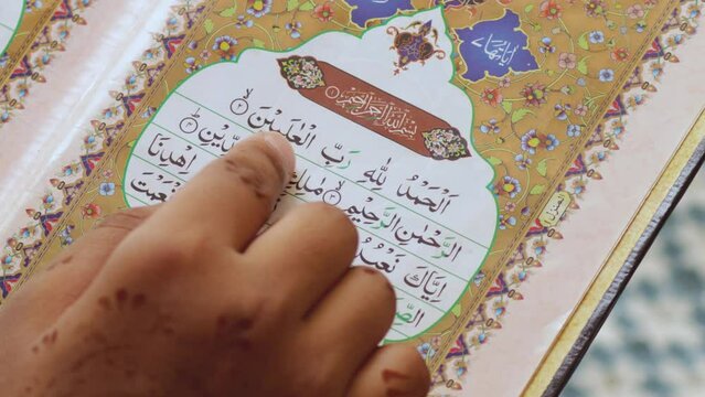 Surah Al Fatiha Rading-11 May 2022. young woman reading the Quran in Arabic 4K Video. close up to finger and Quran. Surah (Al Fatiha) is 1st the Surah of the Quran