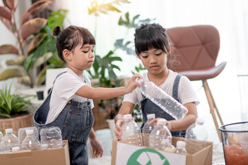 Smiling children having fun while segregating plastic bottles and paper into a bin