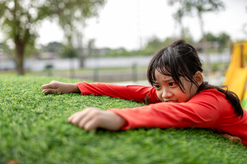 Cute Asian girl having fun trying to climb on artificial boulders at schoolyard playground, Little girl climbing up the rock wall, Hand & Eye Coordination, Skills development