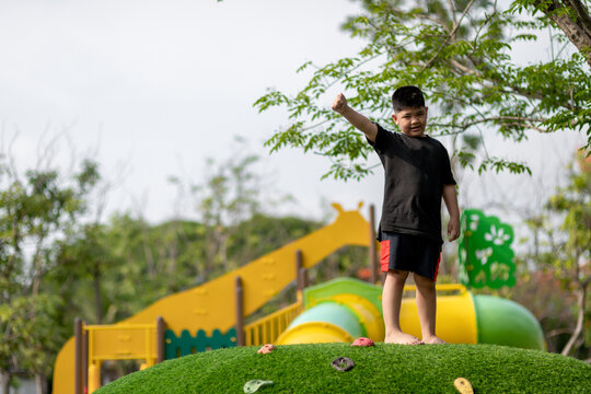 Child Playing On Outdoor Playground. Kids Play On School Or Kindergarten Yard. Active Kid On Colorful Slide And Swing. Healthy Summer Activity For Children. Little Boy Climbing Outdoors.