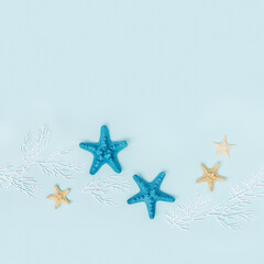 Fototapeta na wymiar Summer flat lay with starfishes and coral on blue background. Summertime or beach concept