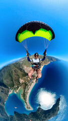 Paraglider pilot flying above Oludeniz beach at sunny day