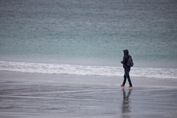 Young man walking on Luskentyre beach on the Isle of Harris, Outer Hebrides, Scotland, United...
