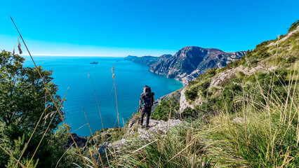 Man with panoramic view from hiking trail Path of Gods between coastal towns Positano and Praiano....