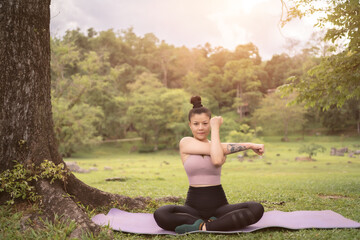 Fototapeta na wymiar asian tattoo young woman doing yoga in the park