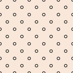 Seamless vector pattern with black polka dots on a sweet pastel pink background