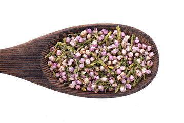A mound of pink heather in a spoon. Dry heather spice. Heather flower.