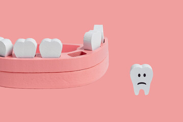 Teeth loss concept. Wooden jaw model with missing or extracted tooth with sad emoji on pink...