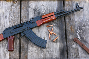 The famous Soviet assault rifle with cartridges on an old, damaged board