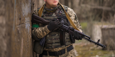 Ukrainian soldier in uniform near a large concrete wall