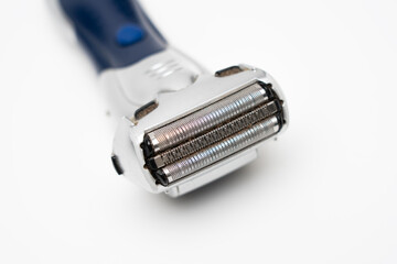 Disassembled electric shaver with remnants of hair close up on a white background
