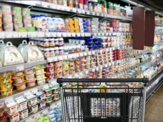 choosing a dairy products at supermarket.empty grocery cart in an empty supermarket