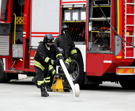 firefighter carrying out the launch of the rolled up hose during the fire drill and the fire truck