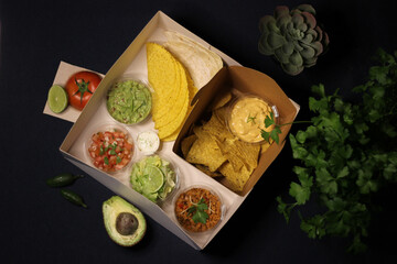 Mexican food box, tex mex, Taco, chili, tortilla, nachos chips, cheddar cheese, guacamole, sour cream, lettuce, tomato