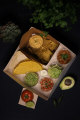 Mexican food box, tex mex, Taco, chili, tortilla, nachos chips, cheddar cheese, guacamole, sour cream, lettuce, tomato