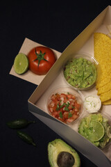 Mexican food box, tex mex, Taco, chili, tortilla, nachos chips, cheddar cheese, guacamole, sour cream, lettuce, tomato