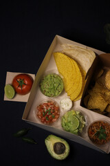 Mexican food box, tex mex, Taco, chili, tortilla, nachos chips, cheddar cheese, guacamole, sour cream, lettuce, tomato