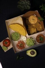 Mexican food box, tex mex, Taco, chili, tortilla, nachos chips, cheddar cheese, guacamole, sour cream, lettuce, tomato
