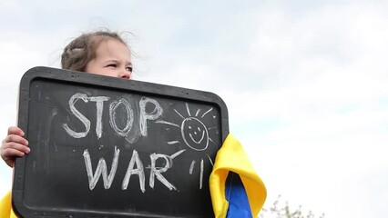Girl with the slogan stop war. Children against war. War in Ukraine. Stop the war. Ukrainian children. Child with Ukrainian flag. Ukrainian children dream of peace