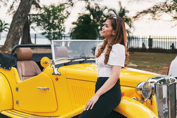 Beautiful woman posing near yellow retro vintage convertible car Kota Kinabalu Sabah Malaysia