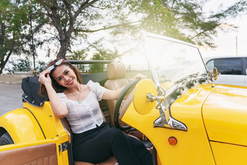Beautiful woman in a yellow retro vintage convertible car Kota Kinabalu Sabah Malaysia