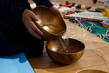 A woman prepares water in copper bowls for the rite of relaxation and aromatherapy