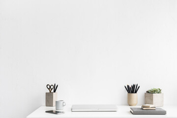 Home office, creative desk with office supplies and beige wall...