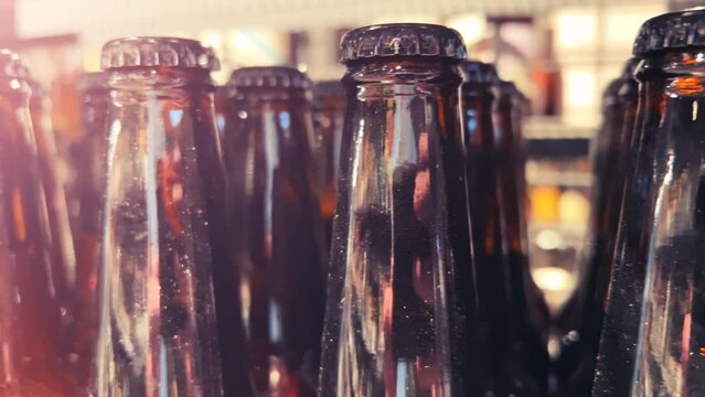 Bottles of dark beer stand on a shelf in a liquor store, ABC store, cellar or pub. Close-up shot