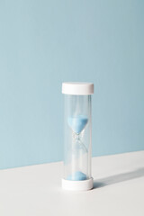 hourglass on blue and white background with shadow. concept of decision making and deadline....