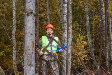 Forest engineer with a measuring tool on the background of the forest.