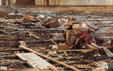 Broken chairs in a pile of garbage in an abandoned building. 