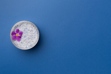 Natural scrub in container on color background, top view