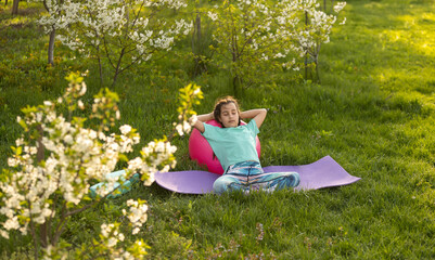 pretty girl doing yoga exercises, little girl doing yoga exercises in the garden.