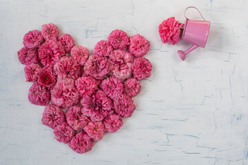 
Pink rose petals heart. Vintage background. View from above.


