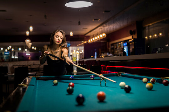 happy woman spend free time at pub, playing in snooker