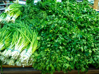 Obraz premium Vegetable shop. Greenery on the board. Showcase of vegetables. Sale of parsley, dill and onion. Vitamin containing products