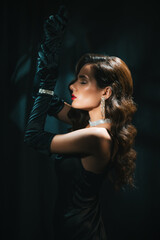 Blurry portrait of woman in style of classic retro Hollywood movie of 1950s. Elegant young girl with a stylish hairstyle and makeup. Concept of vintage female looking soft focus