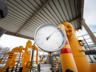 Pressure gauge measuring the pressure on the yellow natural gas pipeline