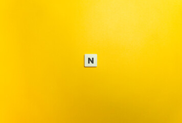 Newton (N) Force Banner. Letter Tile on Yellow Background. Minimal Aesthetics.