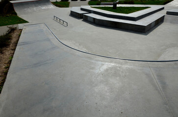 Skateboard park with concrete cement surface with concrete skateboard obstacles is designed for...