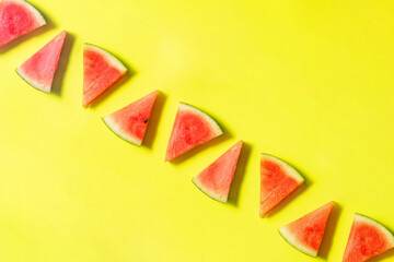 Creative composition with watermelon slices on sunny yellow background. Colorful summer concept. Minimal fresh fruit idea.