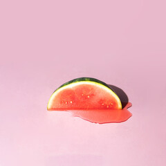 Creative composition with watermelon slice and juice on light pink background. Colorful summer...