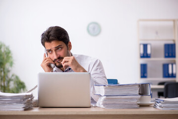 Young male employee unhappy with excessive work in the office