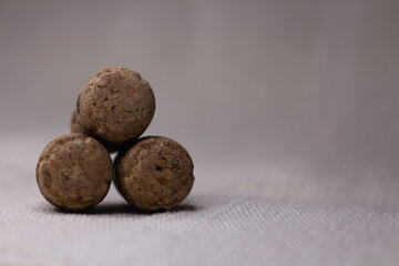 Three wine corks with a pyramid on a light background.