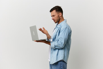 Unhappy irritated tanned handsome man in casual basic t-shirt have problem with broken laptop posing isolated on over white studio background. Copy space Banner Mockup. Electronics repair IT concept